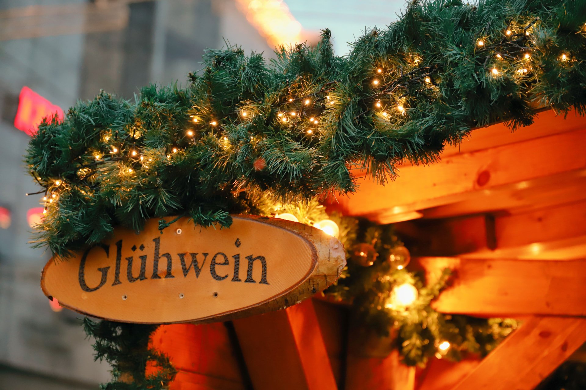 A German Christmas market Glühwein stall trimmed with garland and warm fairy lights