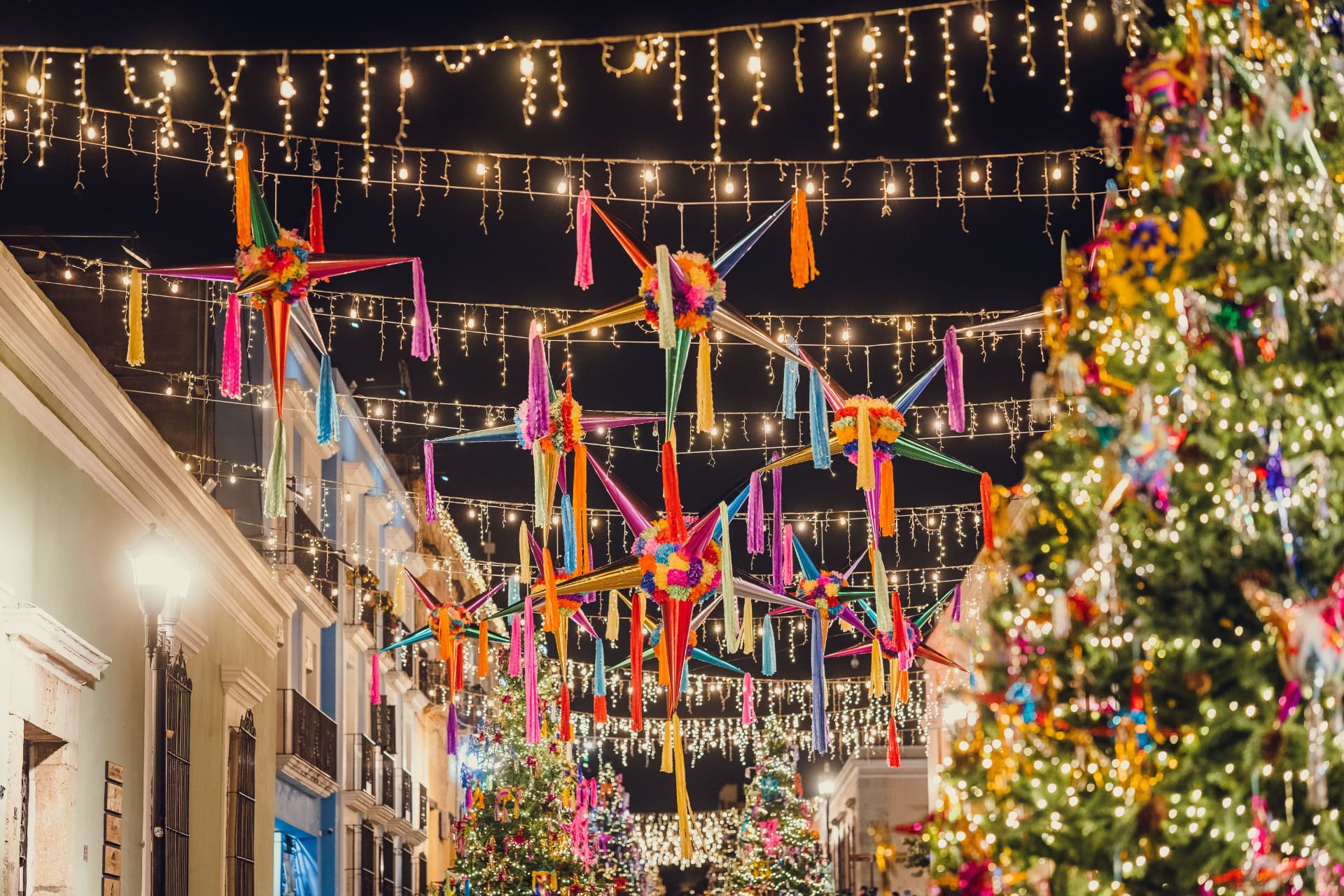 Mexican piñata stars and string lights over a festive street