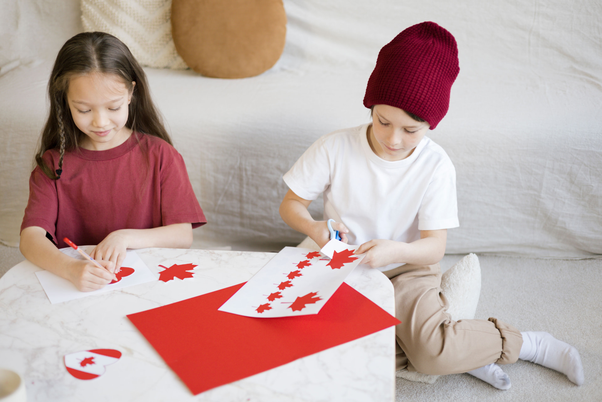 Two children cutting and coloring paper flag crafts together